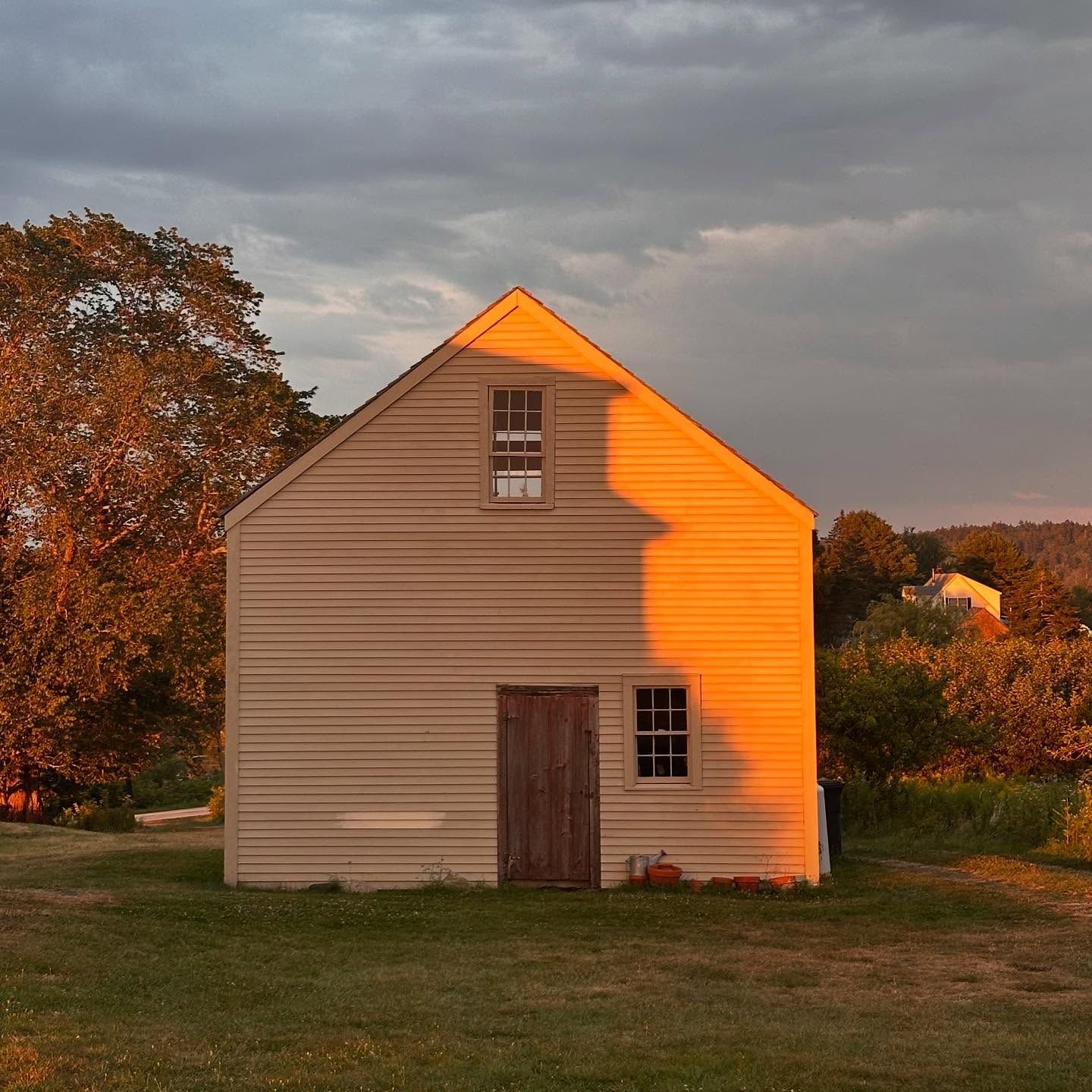 The 1844 farmhouse at 165 Middle Road glowing at sunset